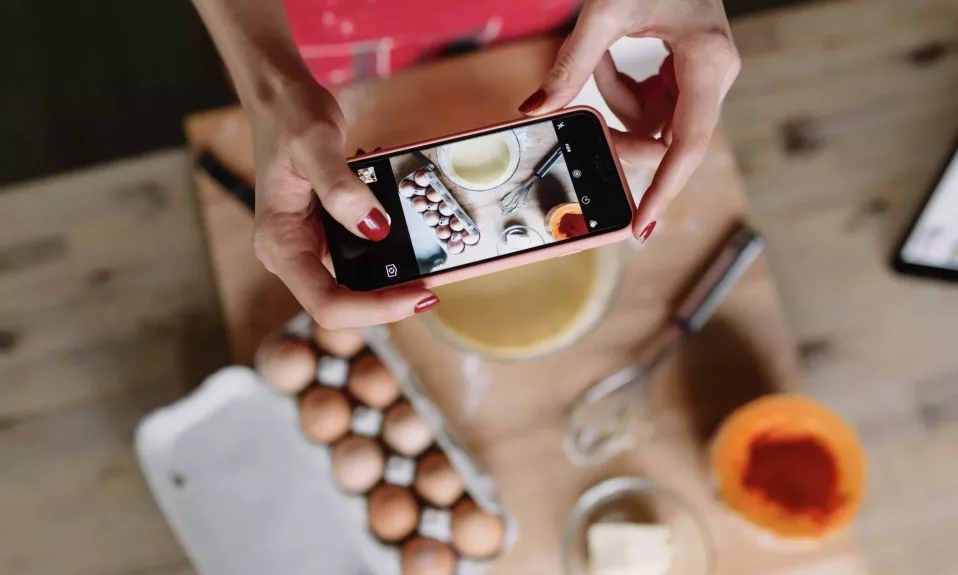 Person taking photo of baking ingredients with smartphone.